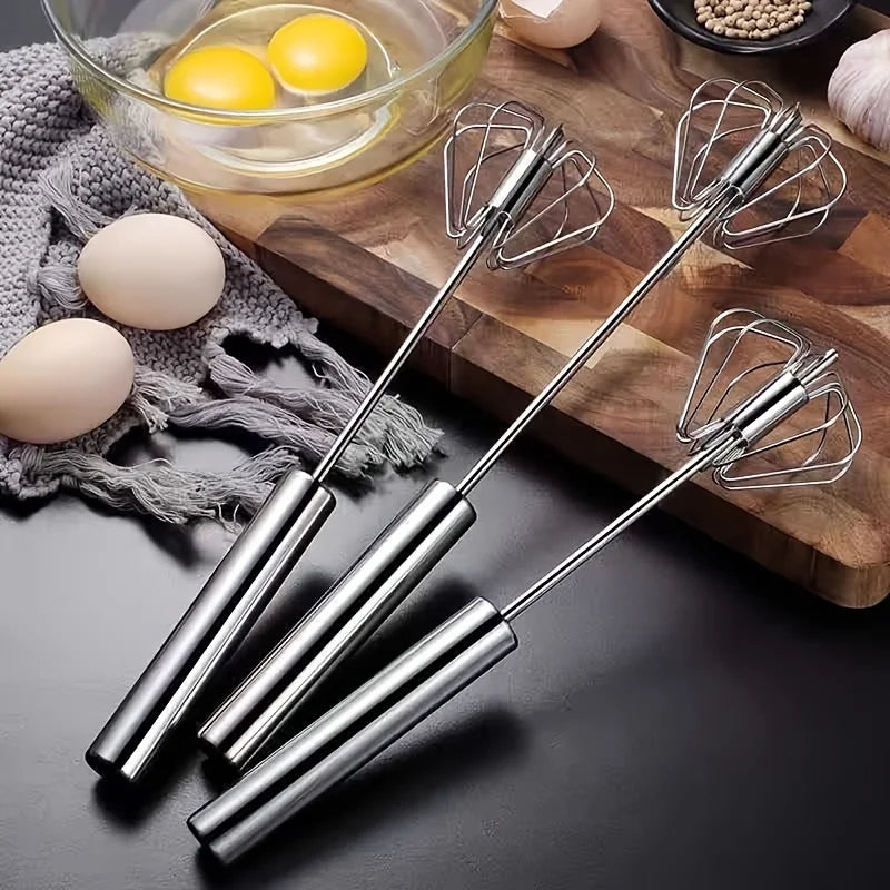 Stainless steel manual egg whisks in different sizes with eggs 