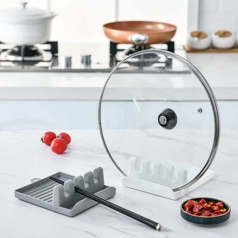 Glass pot lid and kitchen utensil holder on a kitchen counter  