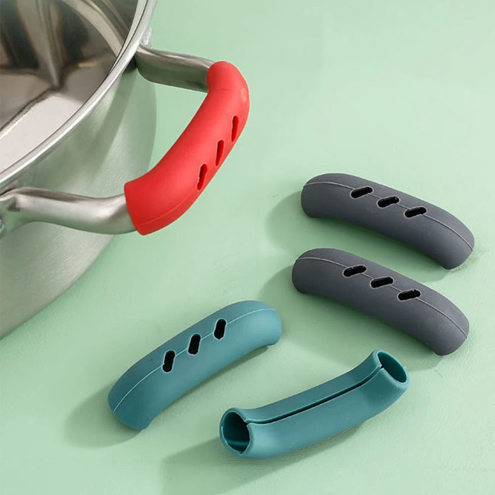Silicone pan handle covers in multiple colors beside a saucepan 