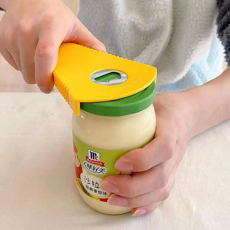 Person using a yellow multi-function jar opener on a jar 