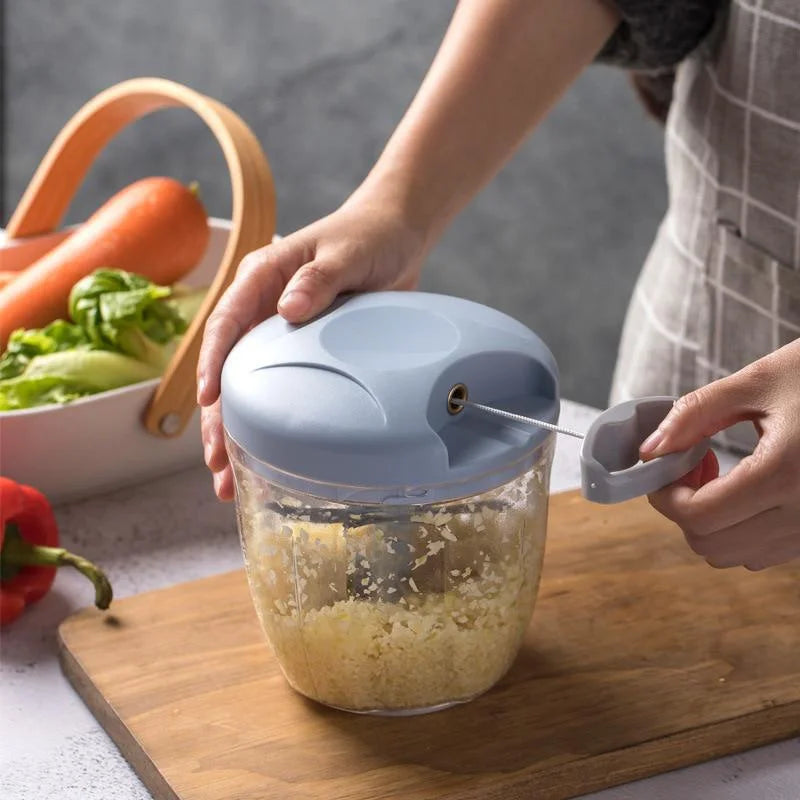 Person using a manual garlic chopper on a wooden cutting board 