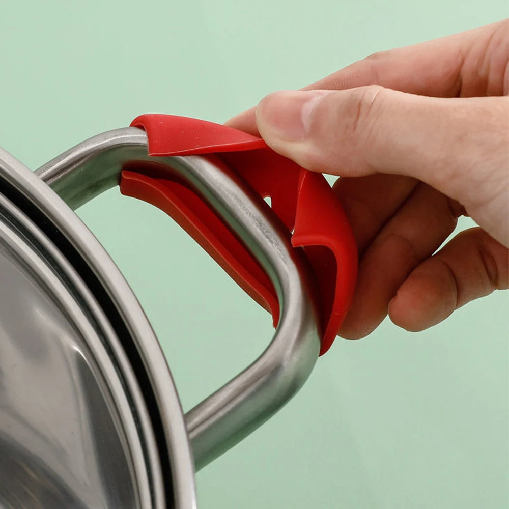 Red silicone pan handle cover being fitted onto a saucepan handle 