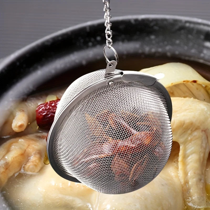 Stainless steel tea infuser ball with chain steeping loose leaf tea in a cup 