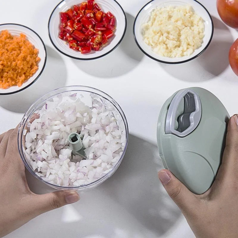 Manual garlic chopper with chopped vegetables in a clear bowl 